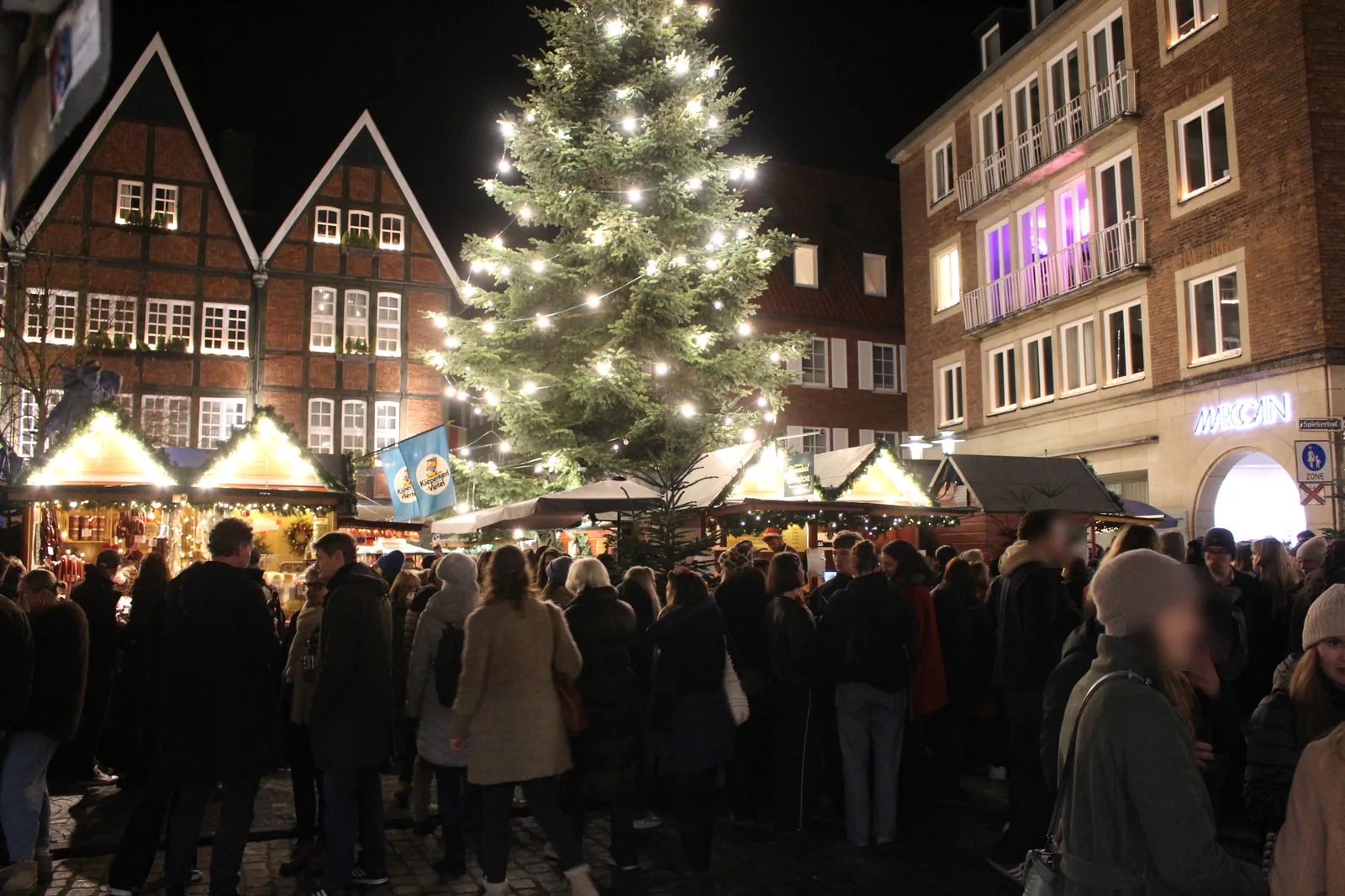 Kiepenkerl Christmas market on the Spiekerhof in Münster: lit stalls and a large Christmas tree among half-timbered gables.
